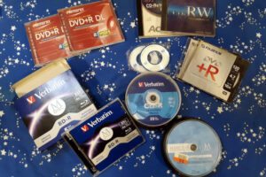 A collection of different optical disk media, including M-Disc Blu-Ray and DVD blank disks.